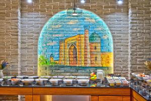 a mural of a building on a brick wall at Afrosiyob Regency Hotel in Tashkent