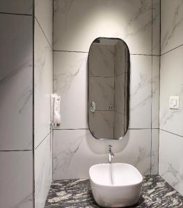 a white bathroom with a sink and a mirror at Mayo Suites in Palakkad +30 photos