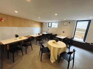 a restaurant with tables and chairs in a room at Panorama Peaks Lodge-Free pickup-Sunrise-Close to the Middle Gate Ticket Office of the Zhangjiajie Foreset Park in Zhangjiajie