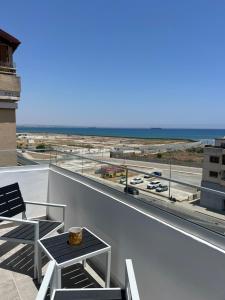 a balcony with a table and a view of an airport at Sea view Appartment in Larnaca