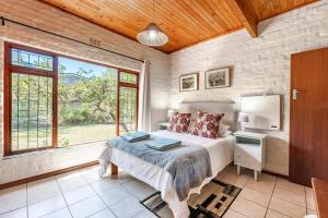 a bedroom with a bed and a large window at Villa Kappri in Natureʼs Valley