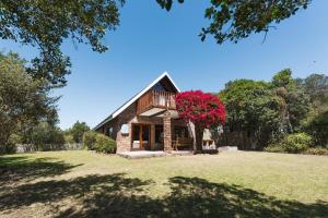 a house with a red flower on the front of it at Villa Kappri in Natureʼs Valley