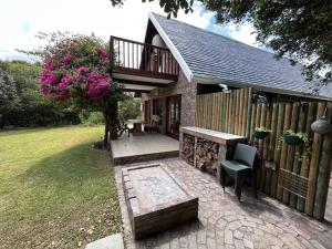 a house with a deck and a table and a chair at Villa Kappri in Natureʼs Valley