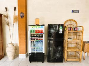 a refrigerator with drinks in it next to a wall at Kubu Elsa Bali in Lovina