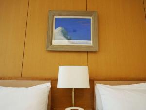 a picture on the wall above two beds with a lamp at Blancvert Nasu Onsen Hotel in Nasu +48 photos