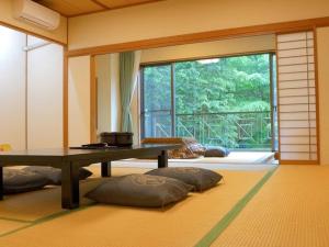 a living room with a table and a large window at Blancvert Nasu Onsen Hotel in Nasu