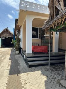 a house with a red table on the front of it at Kituri Hostel in Dar es Salaam