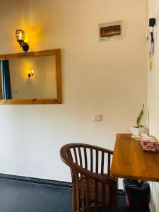a dining room table with a mirror and a chair at Hasara Homestay in Dickwella