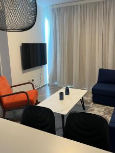 a living room with a table and chairs and a tv at Sea view Appartment in Larnaca