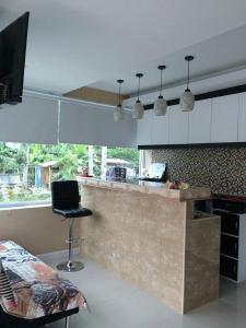 a kitchen with a counter and a chair in a room at Pandora House by Mike Group in Pattaya North