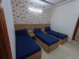 two beds in a small room with blue sheets at The Elite Ambience Hotel in Greater Noida