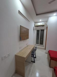 a room with a desk and a tv on the wall at The Elite Ambience Hotel in Greater Noida