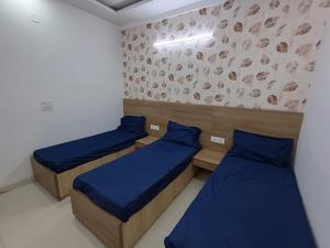 a room with two beds and a wall with drawings on it at The Elite Ambience Hotel in Greater Noida