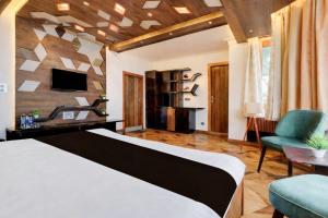 a bedroom with a bed and a tv and a couch at Fun Flock Stay in Mussoorie +44 photos