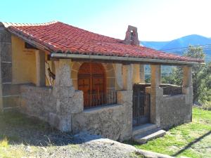 a small stone building with a red roof at Baelo Claudia in Navalguijo