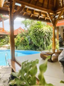 a patio with a bench and a swimming pool at Kubu Elsa Bali in Lovina