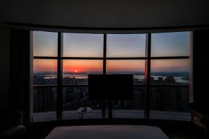a room with a large window looking out at the sunset at Wuhan Marriott Hotel Wuchang in Wuhan