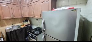 a kitchen with a refrigerator and a sink and a stove at Sheraton Apartment شقة الشيراتون in Cairo