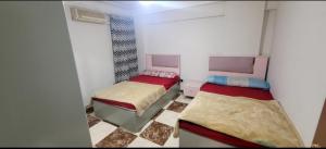 a room with two beds and a window at Sheraton Apartment شقة الشيراتون in Cairo
