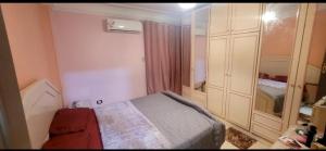 a small bedroom with a bed and a closet at Sheraton Apartment شقة الشيراتون in Cairo