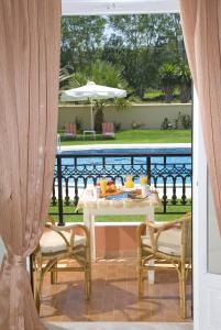 una mesa y sillas en un patio con vistas a la piscina en Dimitris Apartments, en Sidari