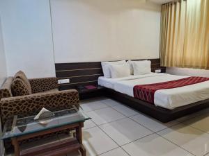 a hotel room with two beds and a chair at Hotel Radiant Kolhapur in Kolhapur +97 photos