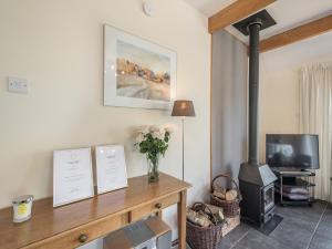 a living room with a wood stove and a tv at Strathmaddie Farm Cottage in Palnure