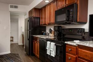 a kitchen with black appliances and wooden cabinets at Club Wyndham Durango in Durango