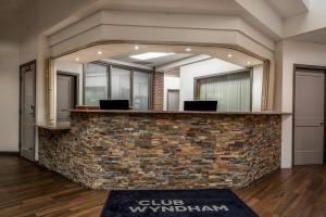 an office lobby with a stone counter with a mirror at Club Wyndham Durango in Durango +35 photos