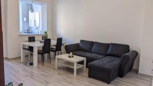 ein Wohnzimmer mit schwarzem Sofa und einem Tisch in der Unterkunft Pejta in Chojnice