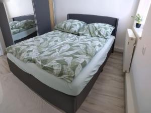 ein ungemachtes Bett in einem Schlafzimmer mit einem Spiegel in der Unterkunft Pejta in Chojnice