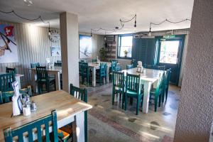 a dining room with tables and chairs in a restaurant at Cabana Vitus Panzió in Harghita-Băi