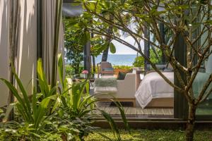 a bedroom with a bed and a view of the ocean at Regent Phu Quoc in Phú Quốc