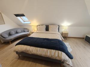 a bedroom with a large bed and a couch at L'échapée belle in Beinheim