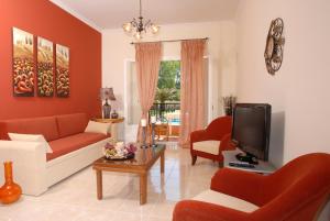 a living room with red furniture and a tv at Dimitris Apartments in Sidari