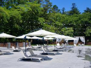 a row of lounge chairs and umbrellas on a patio at Nami Island Hotel Jeonggwanru in Chuncheon