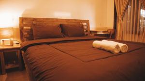 a bedroom with a large bed with a towel on it at Umah Bukit House in Uluwatu