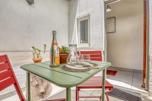 a green table with a bottle and two chairs at French Bistro Studio in Johannesburg