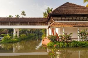 a bridge over a river next to a house at Coconut Lagoon Kumarakom - A CGH Earth Experience in Kumarakom