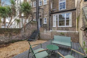 a patio with a table and chairs in front of a building at Well Appointed Garden Condo in Kensington Olympia in London