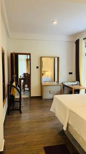 a bedroom with a bed and a desk and a table at All View Resort in Tangalle