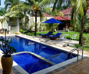 a swimming pool with blue water in a yard at Villa Stella Garden in Senggigi