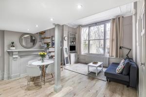 a living room with a blue couch and a table at Well Appointed Garden Condo in Kensington Olympia in London