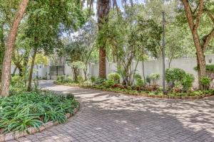 a walkway in a park with trees and plants at French Bistro Studio in Johannesburg