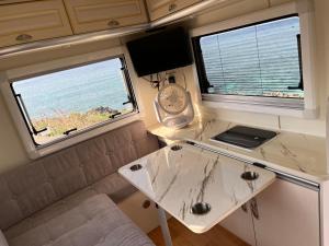 a small room with a table and two windows at ゲストハウス假穂 in Yoron