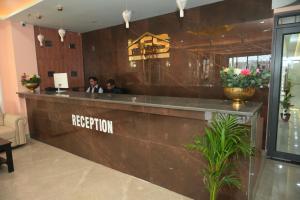 two people sitting at a reception counter in a lobby at Hotel Elite Suites in Padrauna