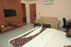 a hotel room with a bed and a couch at Hotel Elite Suites in Padrauna