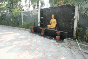 a statue of a buddha sitting on a bench at Hotel Elite Suites in Padrauna