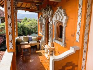 a porch of a house with a couch and a window at Kubu Elsa Bali in Lovina