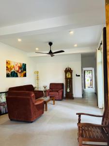 a living room with two couches and a clock at All View Resort in Tangalle